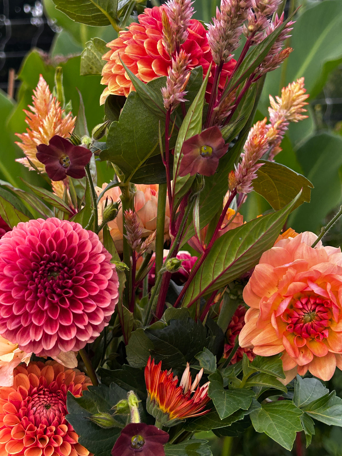 Lush green red orange flower arrangement