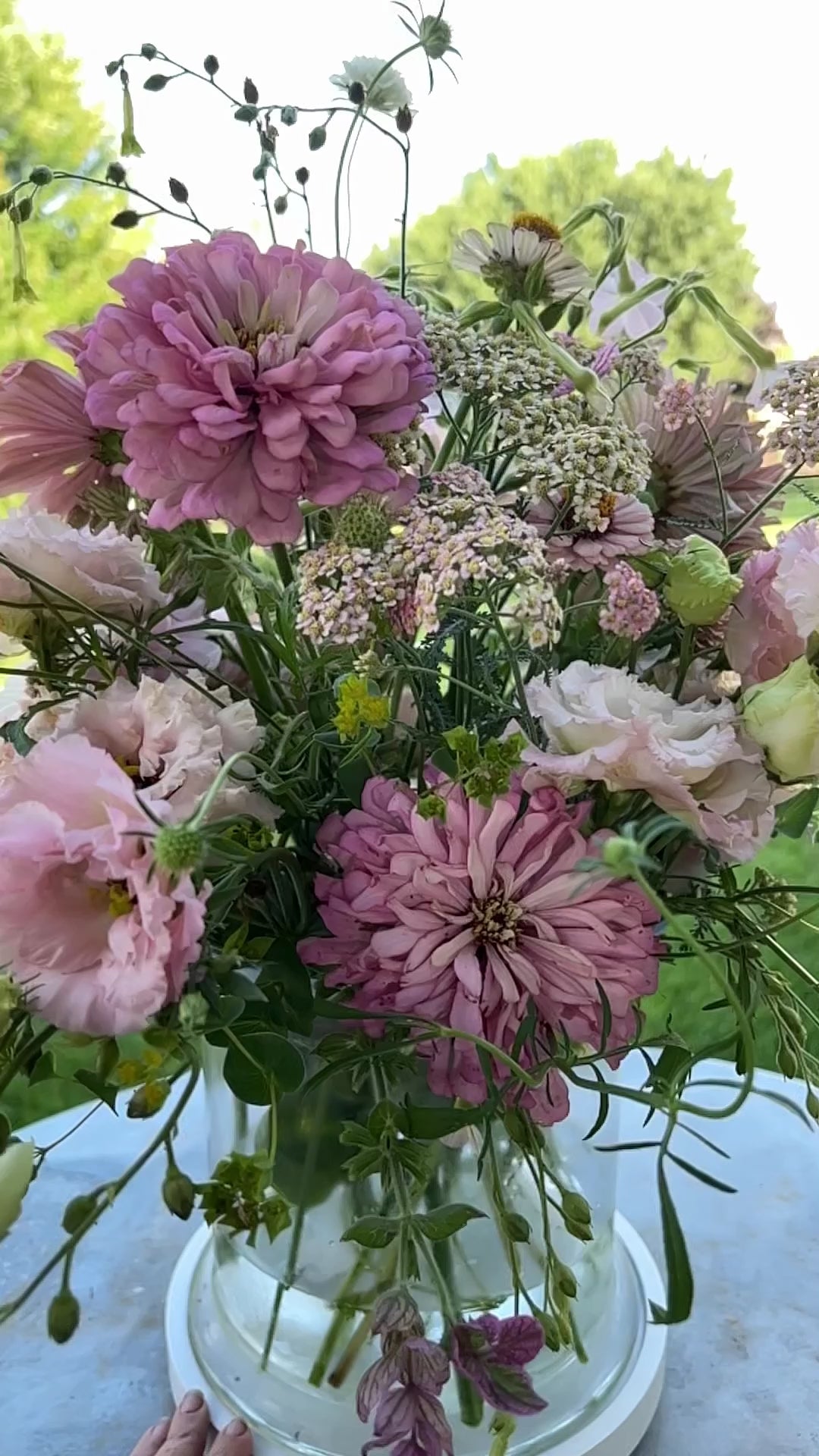 Video in slow motion showing pale pink, white and green blooms in a centerpiece arrangement.