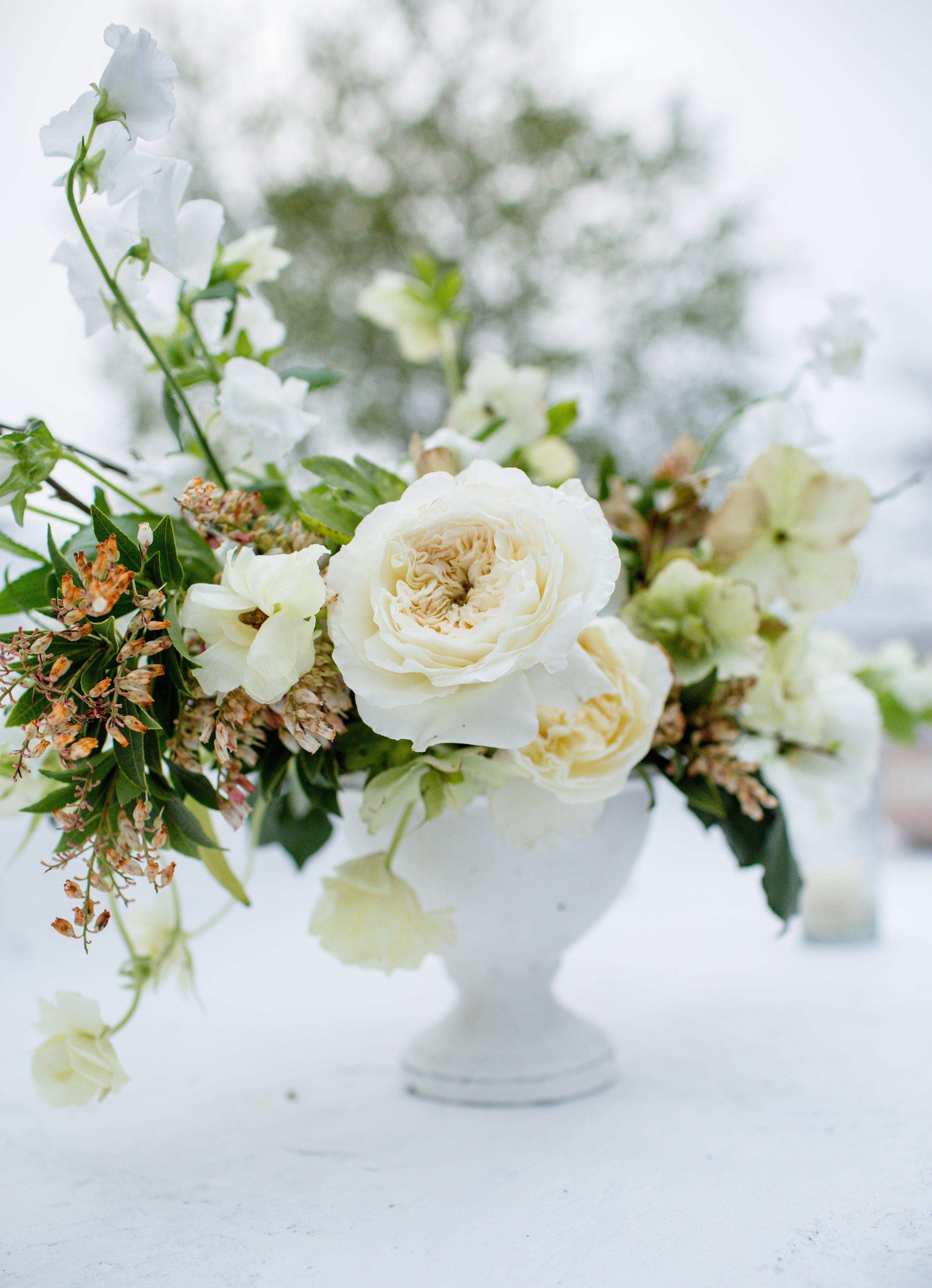 Footed bowl with a cream, white floral arrangement